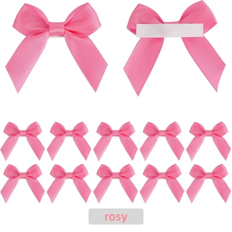 A set of pink satin ribbon bows with white adhesive backing for crafting and gift wrapping