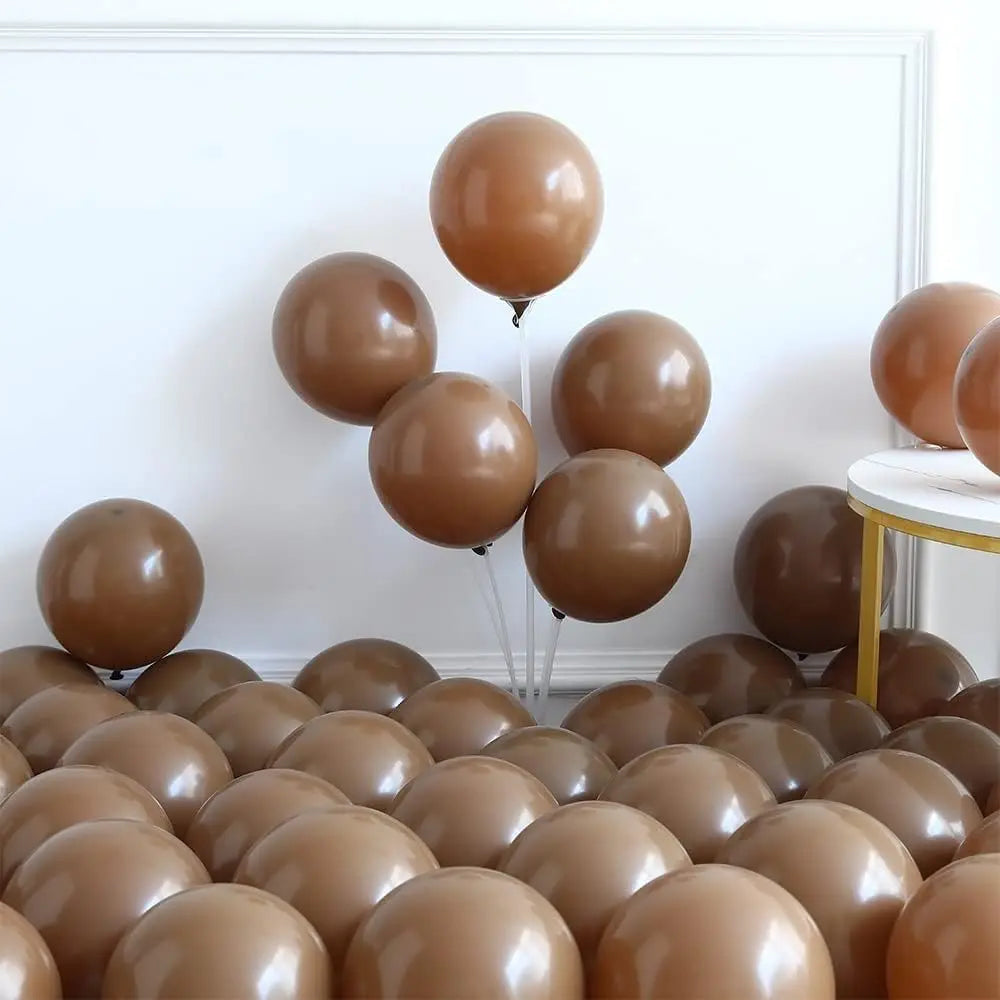 A collection of brown balloons arranged in a display against a white wall.