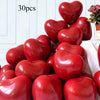 A collection of glossy red heart-shaped latex balloons is displayed on a white surface.