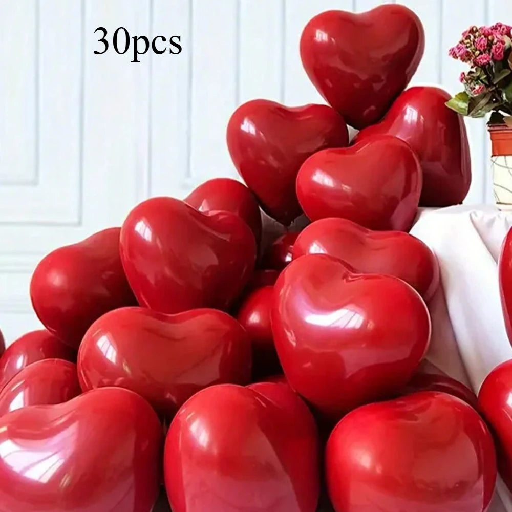 A collection of glossy red heart-shaped latex balloons is displayed on a white surface.