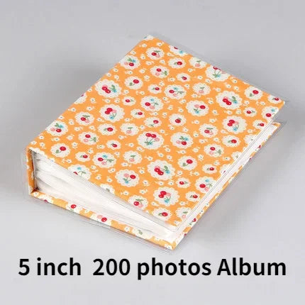 An orange floral patterned photo album with white pages.