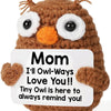 A handcrafted crochet owl doll with brown fur and large white eyes.