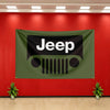 A dark olive green Jeep flag banner is displayed on a red wall with white lettering and a stylized Jeep grille logo.