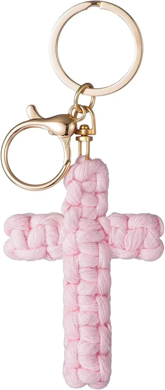 A pink woven cross keychain with a gold-toned split ring and clasp.