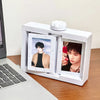 A white rotating flip photocard display frame is shown next to a laptop keyboard.