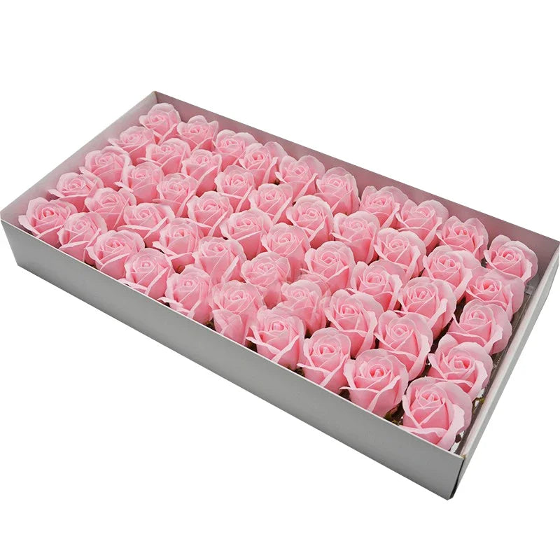 A rectangular box filled with pink artificial rose heads for wedding and party decor.