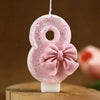 Pink glitter number eight candle shaped like a bow for birthday cake decoration