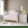 A white crib and dresser in a nursery setting with a window, featuring removable frosted glass film.
