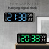 A black digital clock hanging on a gray wall displaying the time 2:38 and temperature 23 degrees.