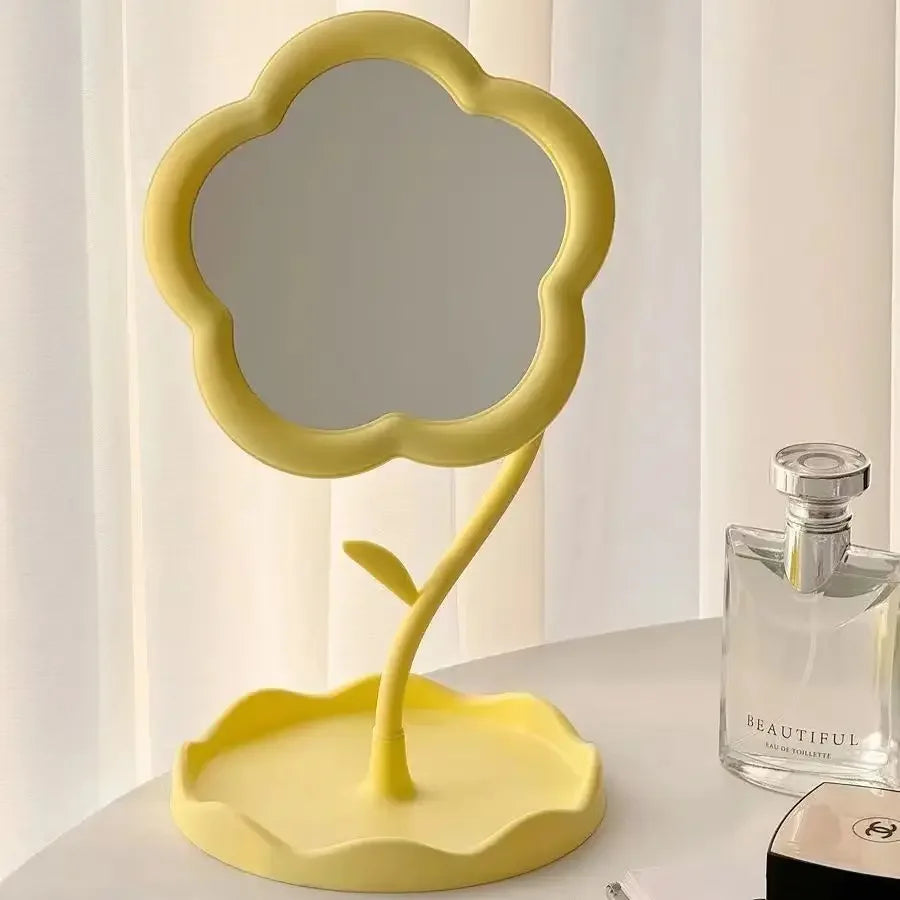 A yellow floral decorative desktop mirror with a scalloped frame and stand.