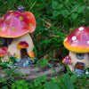 A resin mushroom house garden statue featuring a large red and white spotted toadstool with a small house structure.