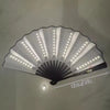 A white folding LED fan with numerous lights is displayed, showing its full spread and size.