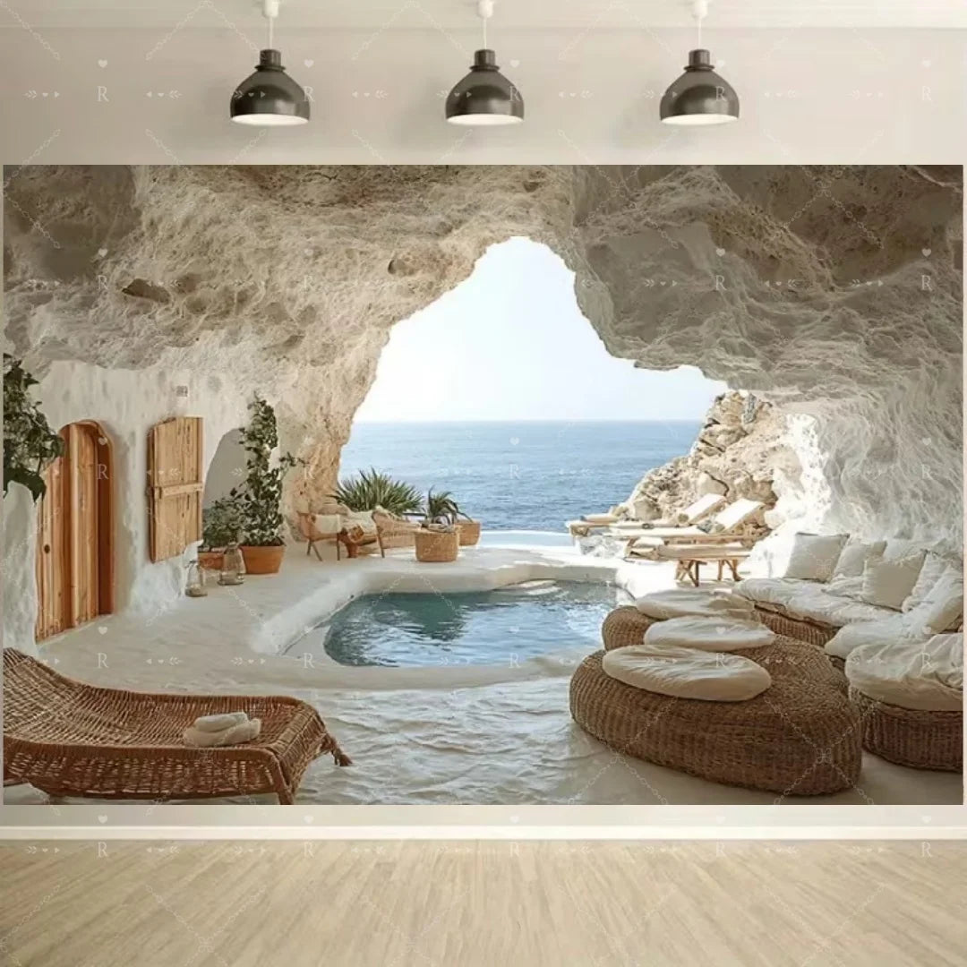 A natural cave opening frames a view of the blue sea and a small infinity pool with lounge chairs.