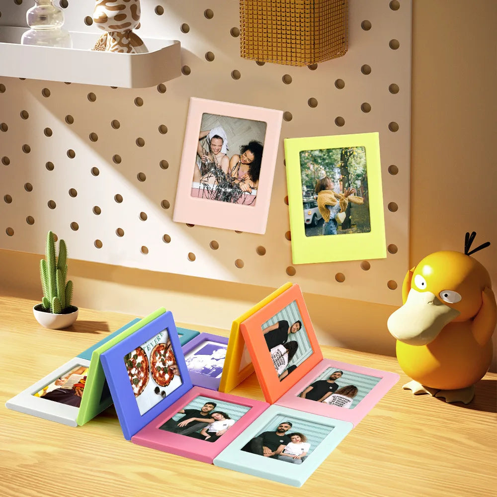 A collection of colorful magnetic mini photo frames displaying various pictures on a wooden surface.