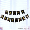 Black and gold pennant banner spelling out Happy Birthday strung across a bright window