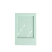 A light mint green desktop photo frame with a white border and two diagonal cutouts.