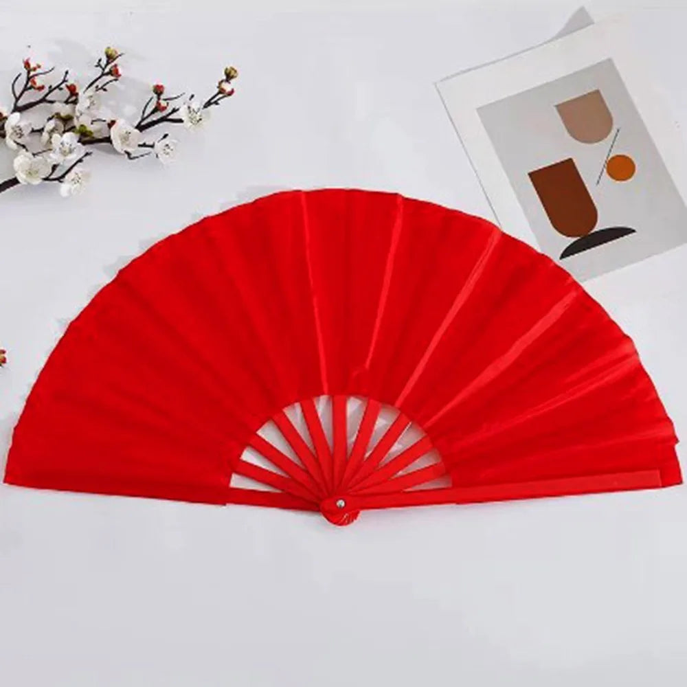 A bright red Tai Chi performance fan with durable plastic ribs is displayed on a white surface.