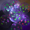 Nahaufnahme von leuchtenden Latexballons mit mehrfarbigen Punkten in der Dunkelheit.