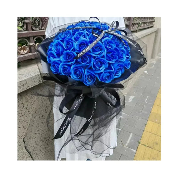 A bouquet of vibrant blue silk roses wrapped in black sheer fabric and ribbon.