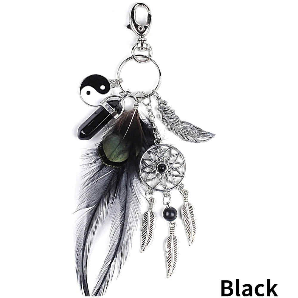 A black bohemian dream catcher keychain featuring a feather and tassel.