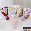 A collection of handmade crochet flower bouquets in various pastel colors like pink, purple, and blue, arranged on a white su