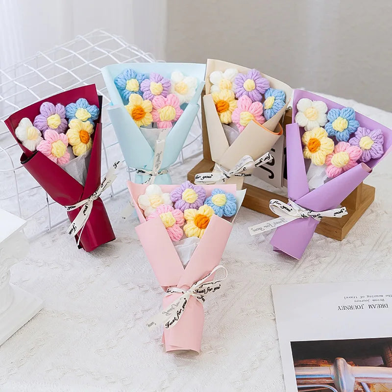 A collection of handmade crochet flower bouquets in various pastel colors like pink, purple, and blue, arranged on a white su