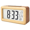 A light wood digital alarm clock displaying 8:33, with separate displays for alarm, month, date, and temperature.