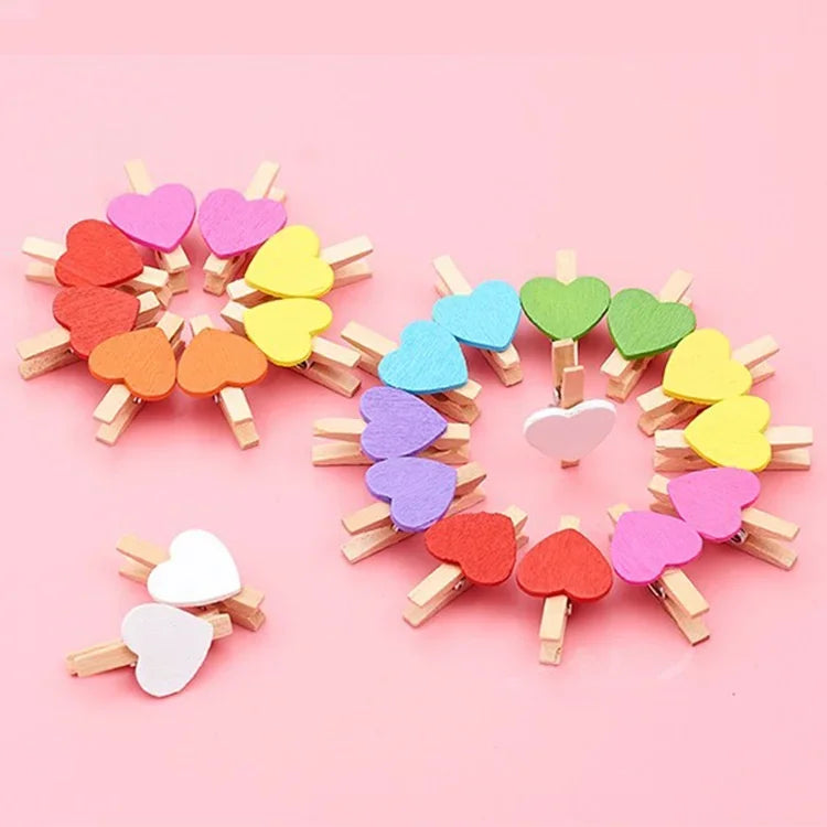 A circular arrangement of small wooden heart clips in various pastel colors like pink, yellow, and green.
