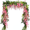 A lush green garland featuring pink silk wisteria vines and flowers for wedding or home decor.