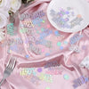 Pink satin fabric scattered with holographic disco confetti stars and circles for a birthday party