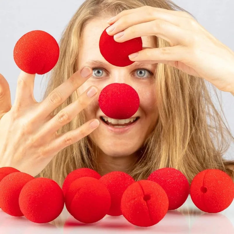 A woman is holding a red foam ball, demonstrating the classic red clown nose product for costumes and parties.