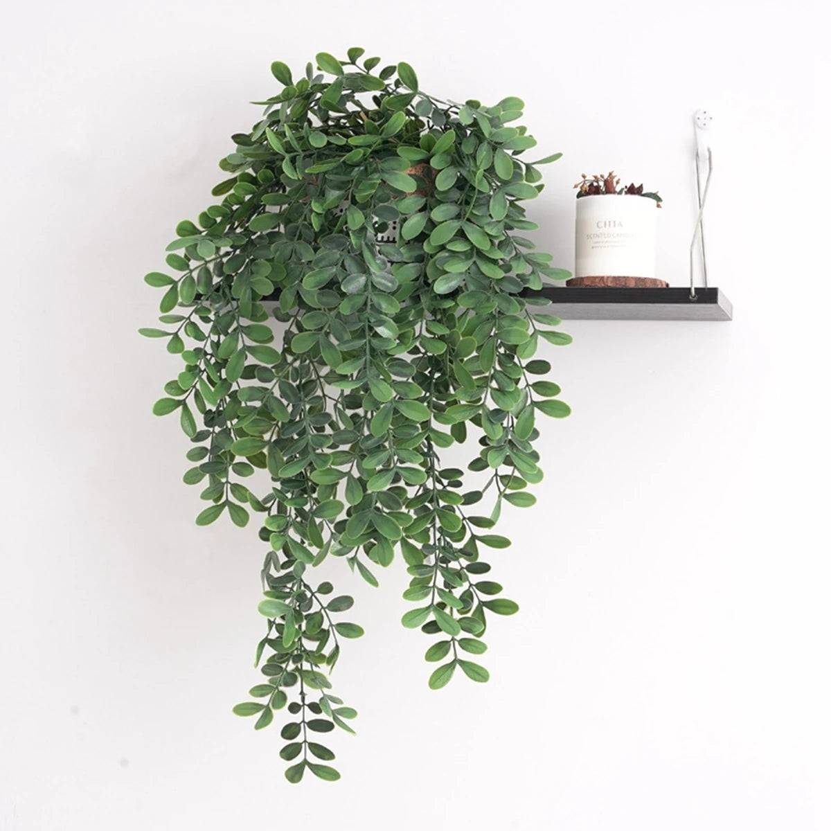 Artificial ivy vine cascading from a shelf, decorated with small wood accents.