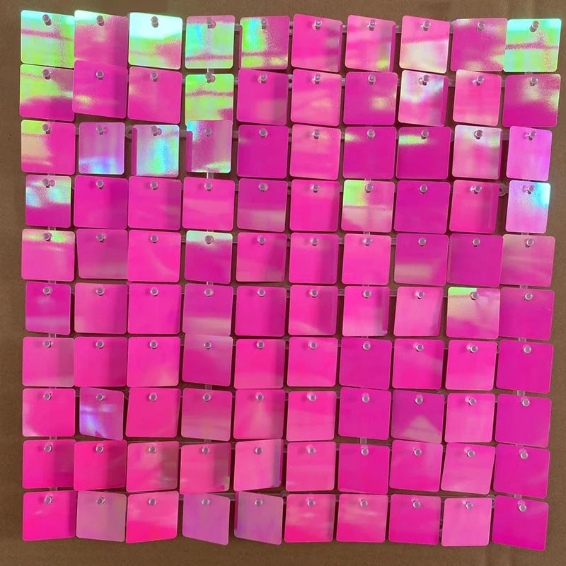 A grid of iridescent pink and magenta sequin shimmer wall panels used as a sparkling backdrop.