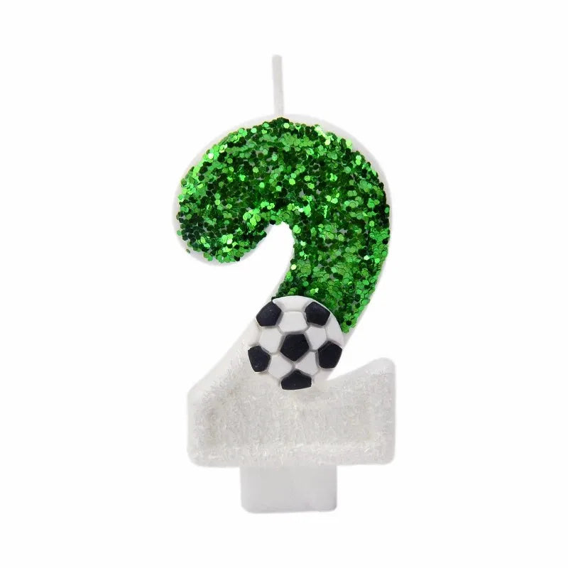 A number 2 candle decorated with green glitter and a soccer ball topper for a birthday theme