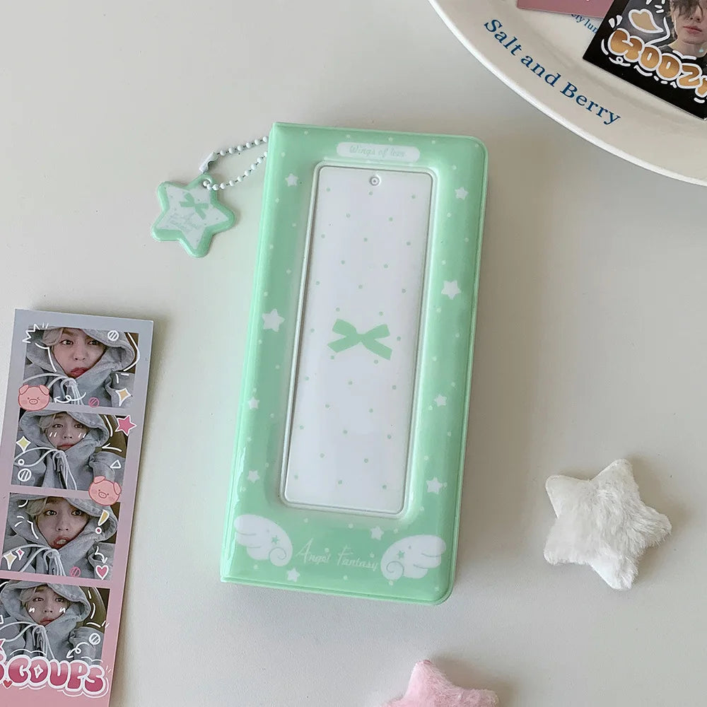 A green photo booth album with a clear window and decorative elements rests on a white surface.