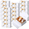 White gift boxes with gold ribbon ties and a small box containing a cat figurine