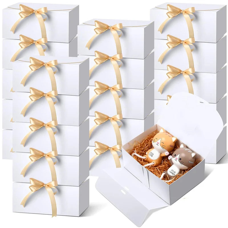 White gift boxes with gold ribbon ties and a small box containing a cat figurine