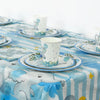 A blue and white striped tablecloth set with elephant-themed disposable party plates and cups.