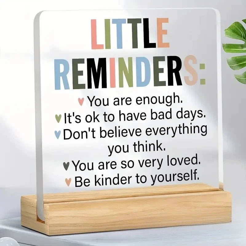 An acrylic desk sign with a positive message listing several encouraging phrases like You are enough and Be kinder to yoursel