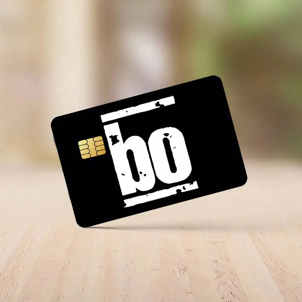 A black card with white text 'bo' and a gold chip icon lying on a wooden surface.