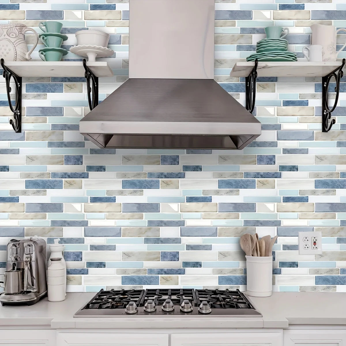 A stainless steel range hood is mounted above a white countertop with a blue and white marble pattern backsplash.