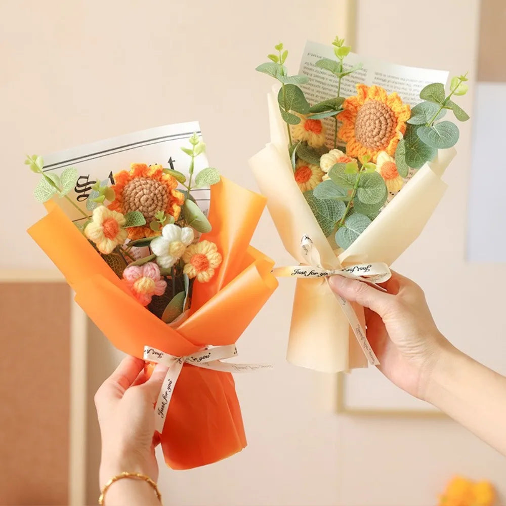 A handmade sunflower daisy crochet bouquet wrapped in orange paper and natural greenery.