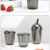 Three disposable U-shaped coffee cups in black glass and silver lids are displayed on a white surface.