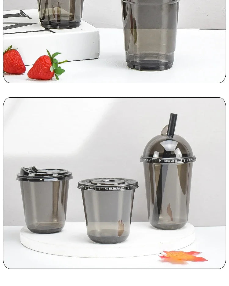 Three disposable U-shaped coffee cups in black glass and silver lids are displayed on a white surface.