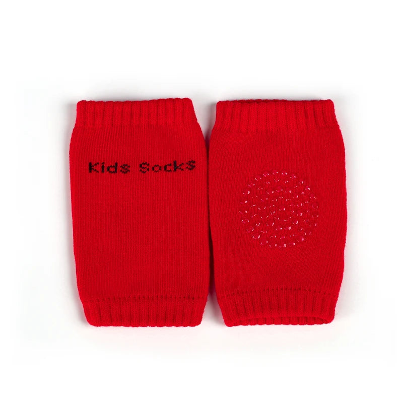 A pair of bright red knitted knee pads for crawling infants.