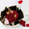 A bouquet of deep red artificial roses with gold glitter accents displayed in a black decorative box.