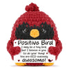 A handmade crochet bird ornament with red body and black markings, featuring a positive message.
