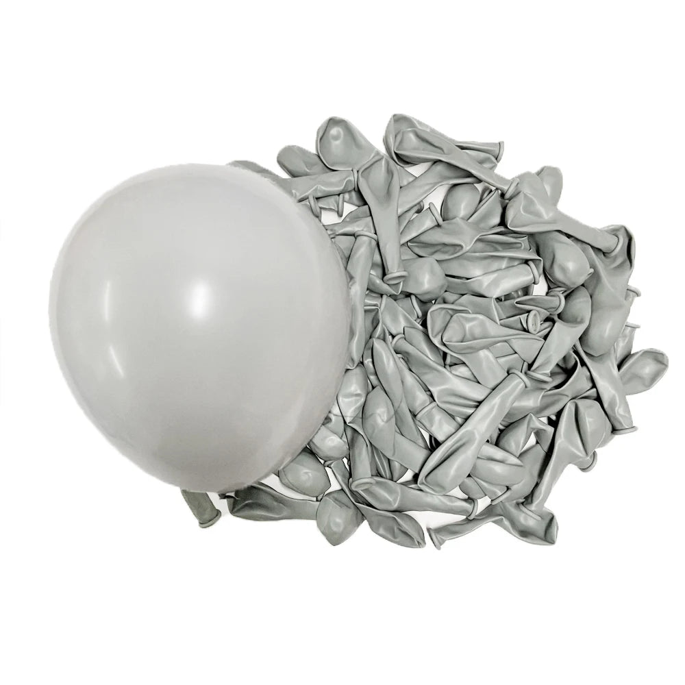 A white latex balloon next to a pile of small, silver-gray latex balloons.