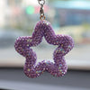 A purple rhinestone star charm hanging from a silver chain.