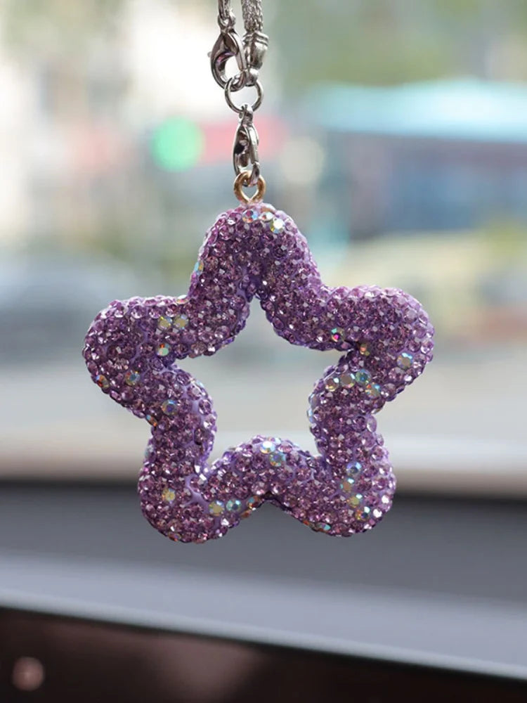 A purple rhinestone star charm hanging from a silver chain.